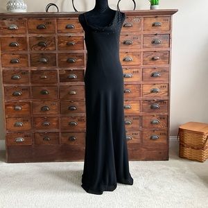 Black slim line evening gown with sparkle accent on left side shoulder.